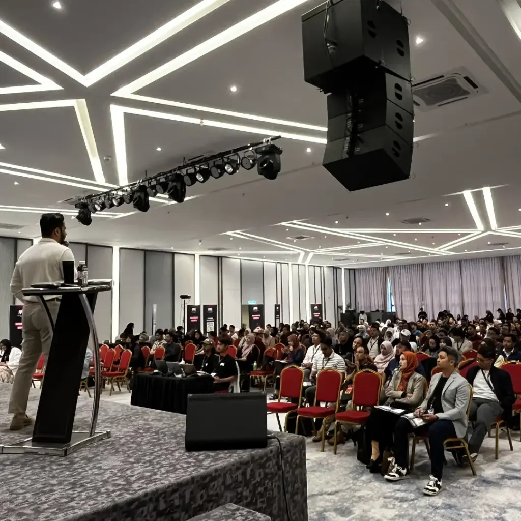 Speaker addressing large audience indoors