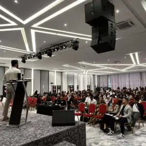 Speaker addressing large audience indoors